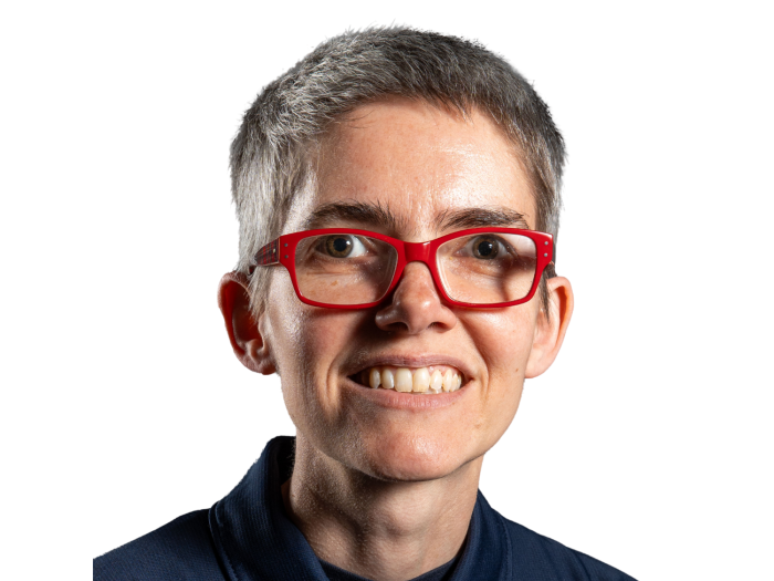 White person with short gray hair, red glasses, in a blue polo